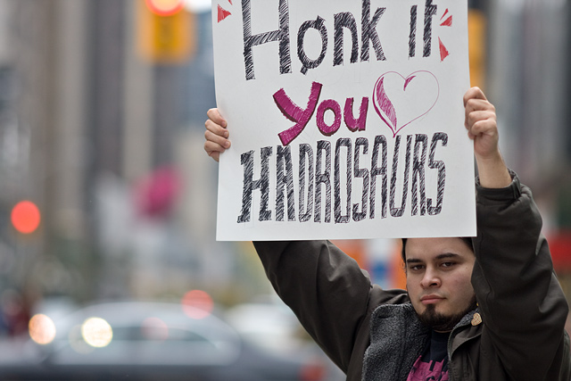 dino_protest_14 Agent Fork holds his sign towards the cars driving by